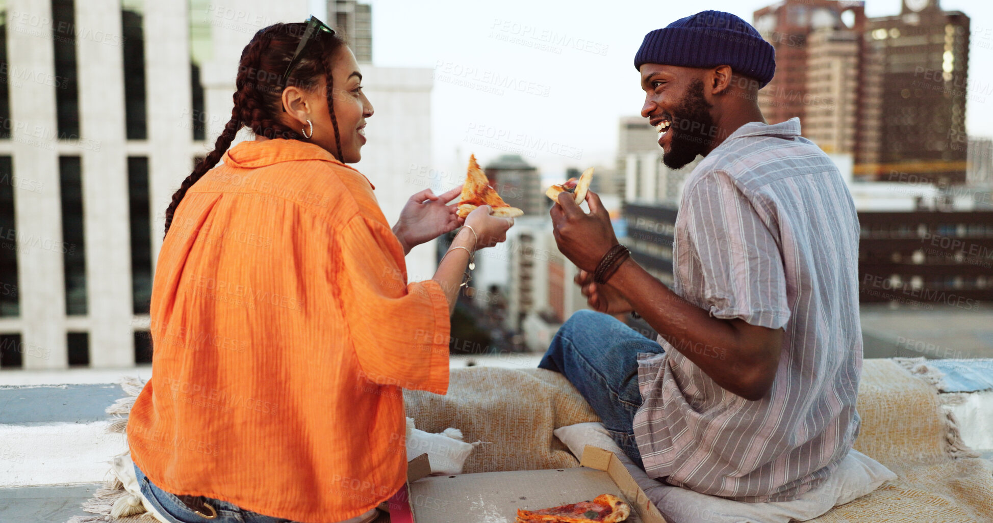 Buy stock photo Couple, food and pizza outdoor on rooftop for picnic, love and happiness. Behind a man and woman eating together for city travel, urban date and freedom or relax with conversation in New York