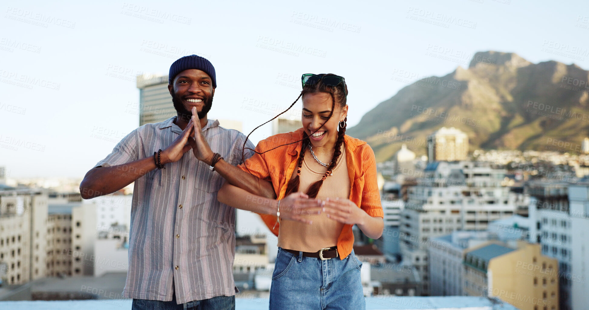 Buy stock photo Couple of friends, dancing and outdoor on city rooftop with fun energy, love and happiness. Interracial man and woman dancer together for travel, urban date and funny namaste game in Cape Town