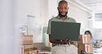 Laptop, creative and online order with a black man designer working in a workshop for shipping or delivery. Computer, ecommerce and logistics with a male managing stock or the shipment of goods