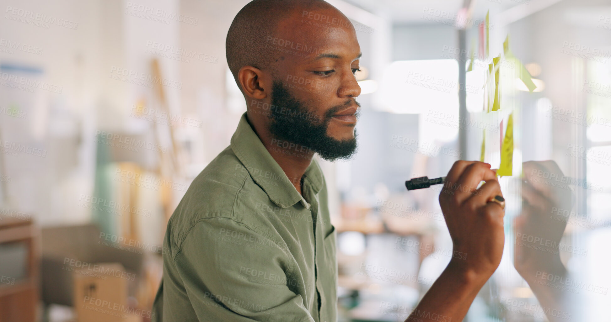 Buy stock photo Planning, whiteboard and sticky notes with a business black man in the office for brainstorming or problem solving. Writing, thinking and strategy with a young employee working on a company game plan