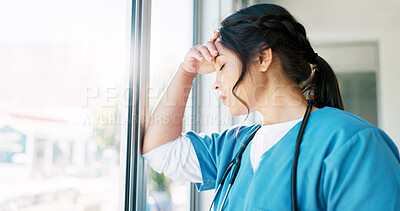 Woman doctor, headache and burnout by window with stress, tired or sad in hospital workplace with pain in head. Professional medic, mental health problem and clinic with anxiety from healthcare job