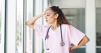 Doctor, woman and stress by window with headache, burnout or sad in hospital workplace with hand on head. Black woman, healthcare medic and mental health problem at clinic job with anxiety in Atlanta