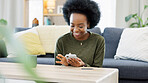 Excited black woman chatting in dating app using her phone at home. A young female online shopping happy about a purchase in her house. A lady celebrating after reading good social media news