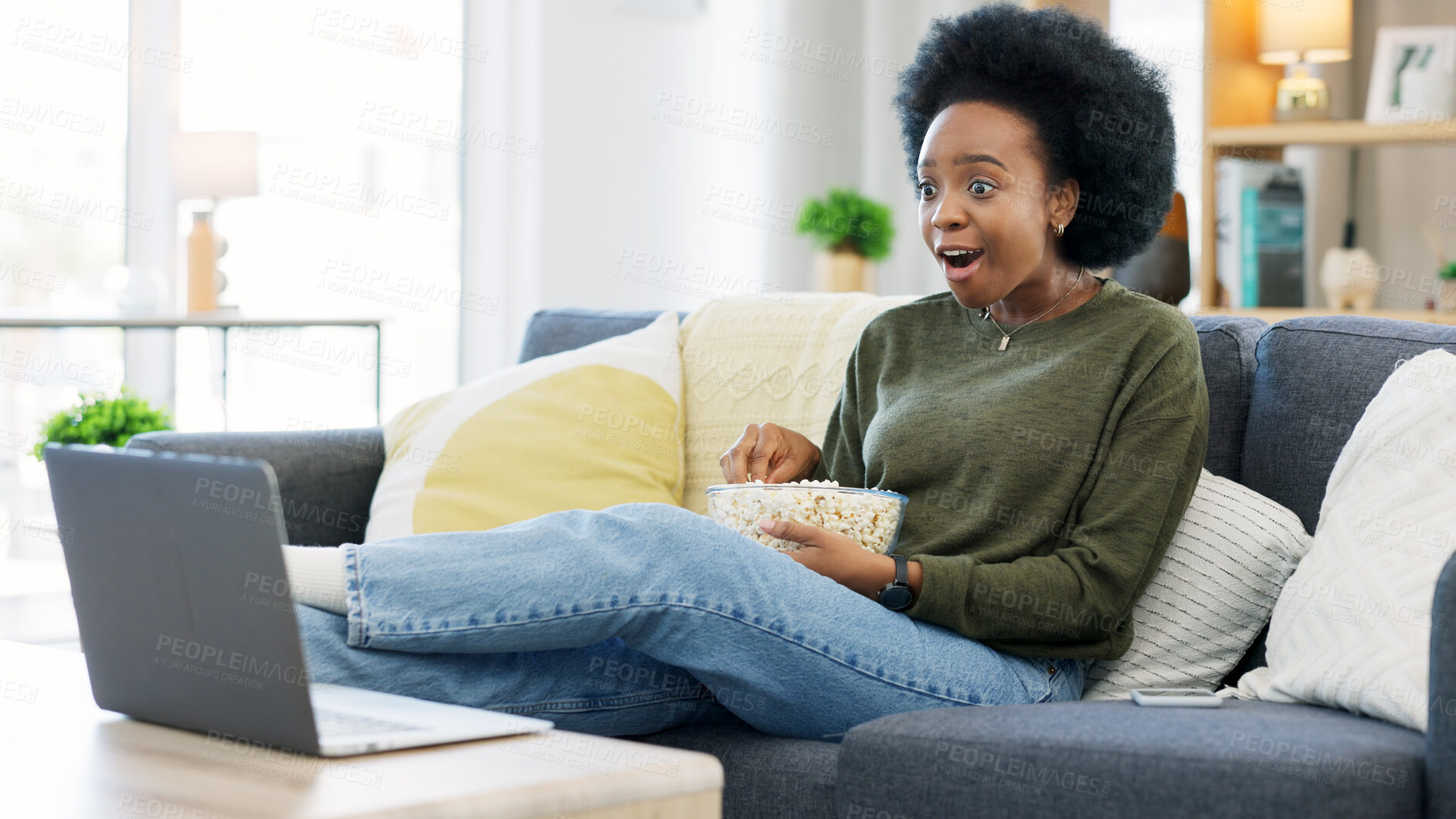 Buy stock photo Popcorn, surprise and black woman with a laptop, movie and connection with network, relax and fun on a weekend. African person, home and girl on a couch, cinema snack and streaming a film with shock