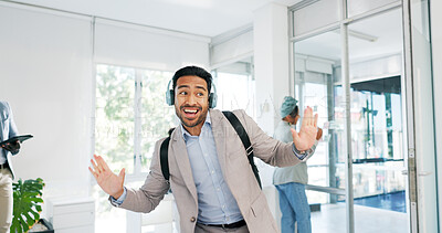 Music, dance and motivation with a business man walking in an office while feeling positive or carefree. Success, happy or smile with a happy male employee arriving at work in headphones with a smile