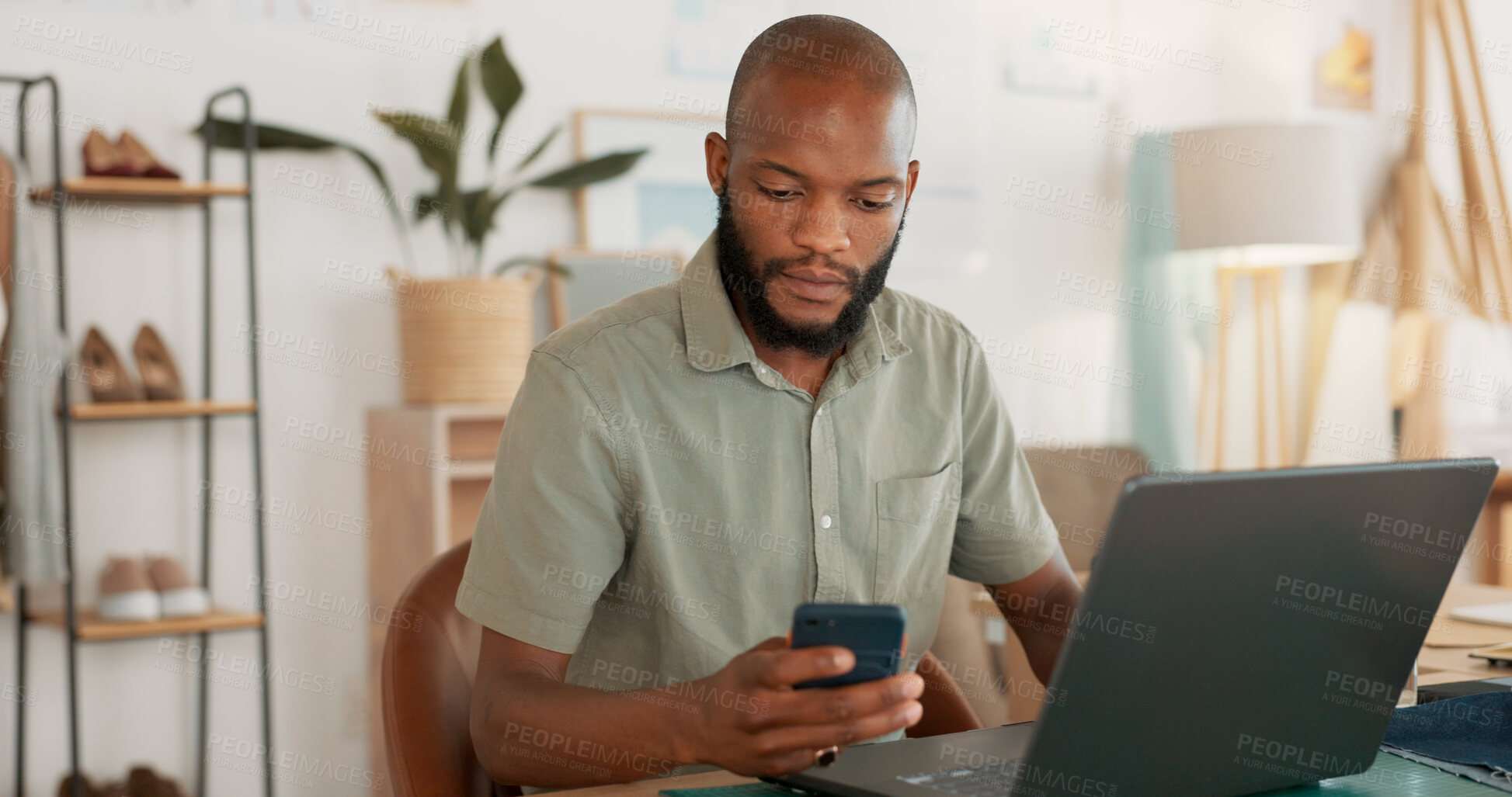 Buy stock photo Laptop, phone and message with a black man designer in an office for work on a creative project. Design, communication or networking with a young employee in a workplace for social media marketing