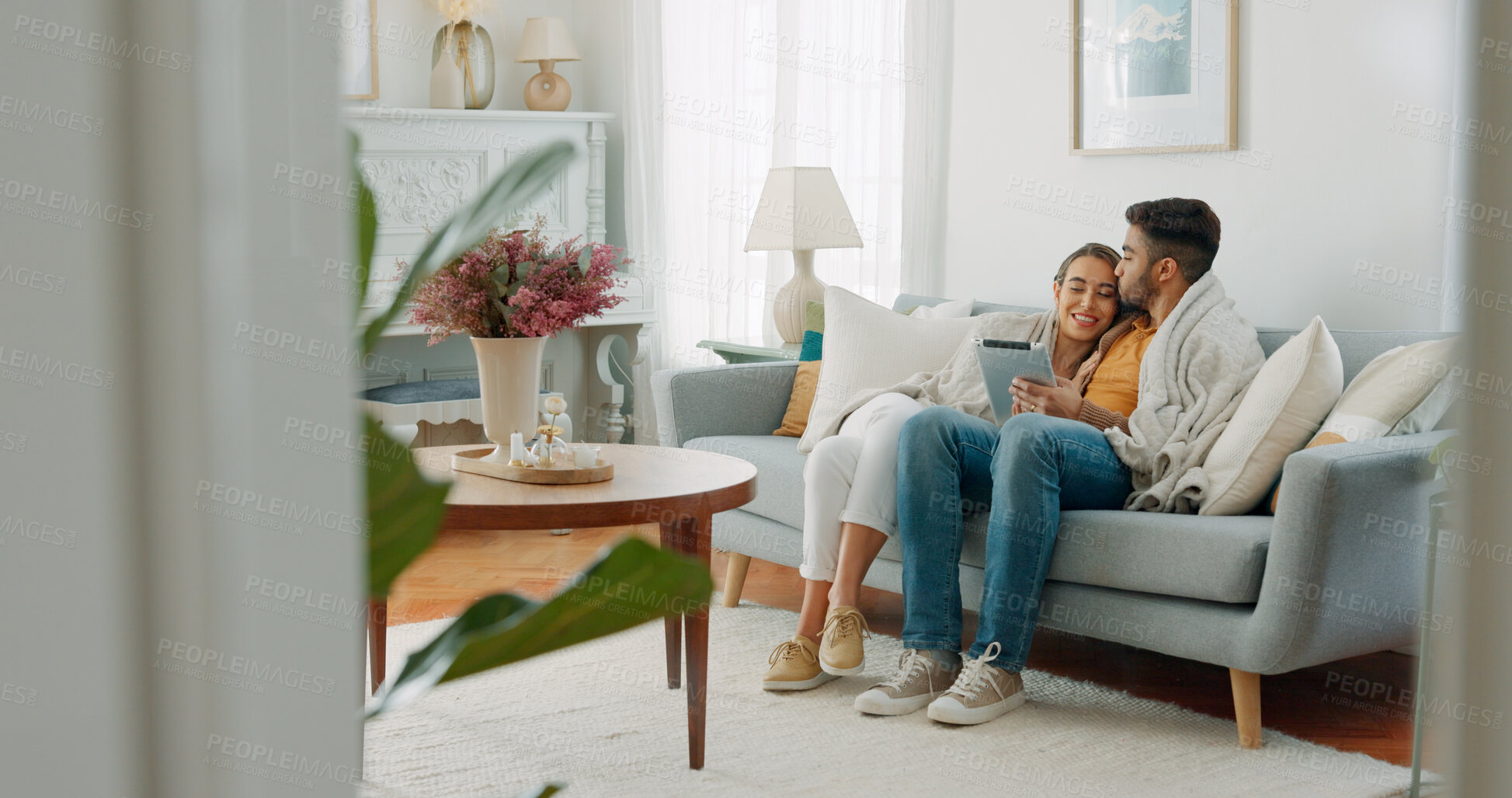 Buy stock photo Happy couple relax on sofa with tablet, kiss and hug, networking or social media in home. Movie, video or digital app, man and woman embrace in living room streaming online, love and smile in house.