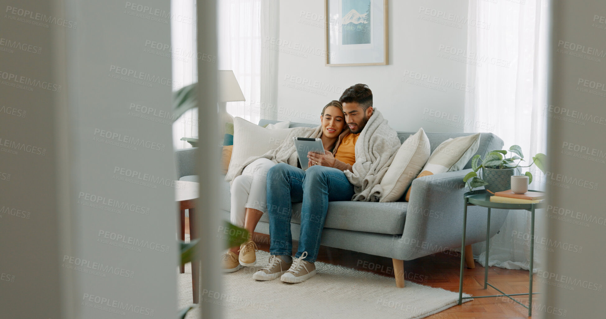 Buy stock photo Happy couple relax on sofa with tablet, hug and scroll, networking or social media in home. Movie, video or digital app, man and woman embrace in living room streaming online, love and smile in house