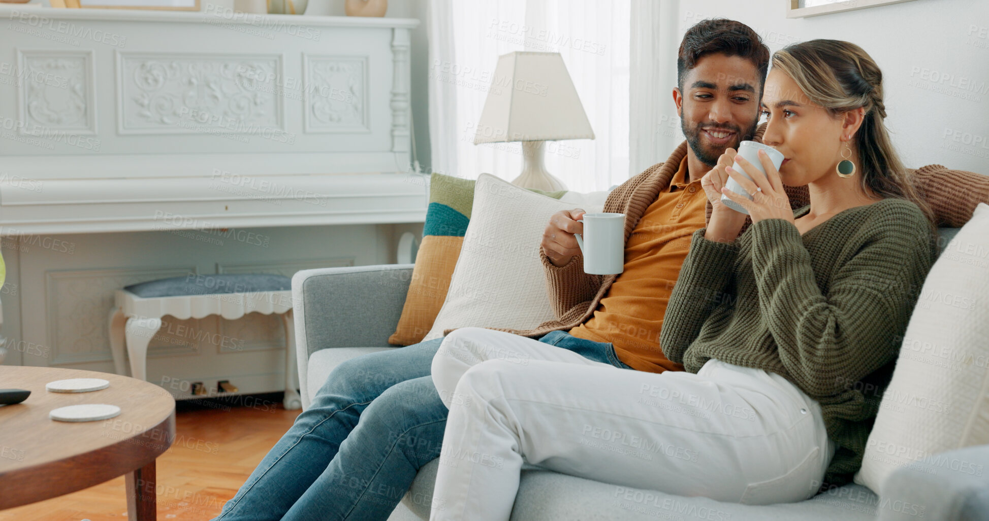 Buy stock photo Couple relax on sofa with coffee, bonding and love with time together at home, warm drink and conversation. Man, woman and communication with peace in living room, life partner or marriage with tea