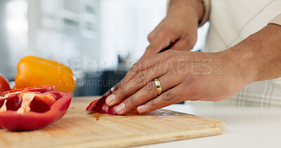 Hands, food and nutrition with a man cooking in the kitchen while cutting vegetables on a wooden chopping board. Salad, health or diet with a chef preparing a meal while standing alone in his home