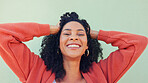 Freedom, hair and fun with a young woman playing with her curly hairstyle and laughing on a green wall background. Happy, funny and smile with an attractive and playful young female feeling carefree