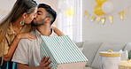 Surprise gift, present bag and happy couple for birthday celebration in home living room with love, kiss and excited. Girlfriend giving box for birthday party together for date, discount and commerce