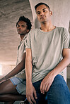 Portrait, fashion and diversity with friends in an urban city together for grunge style on a concrete background. Confident, streetwear and gen z with cool young men sitting in a town to relax