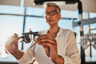 Buy stock photo Trial frame, optometry and hands of woman in hospital or clinic for optician eye test. Vision, healthcare and senior female doctor or ophthalmologist holding equipment for examination of eyesight.