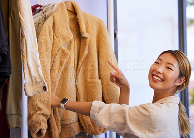 Buy stock photo Shopping choice, portrait and Asian woman looking at sales deal and discount clothes in a store. Fashion, smile and Japanese female customer with a clothing promotion in mall and boutique market