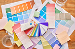 Color palette paper on table for background in design choice, branding and creativity career, project or planning. Colorful charts, sticky note and print paper for creative or brand development above