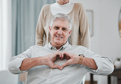 Buy stock photo Portrait, heart or hand gesture with a senior man and his wife together in their home for love or health. Face, emoji and romance with a mature couple bonding in a house to relax during retirement
