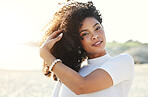 Black woman, beauty and portrait at beach for vacation, freedom and face with natural hair and smile. Happy young model person outdoor in nature for peace, travel and time to relax on sunset holiday