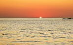 Sunset, ocean and horizon with a view over the sea during summer under an orange sky for mockup. Nature, water and earth with waves on a seascape for zen, peace or inspiration on a sunrise backdrop