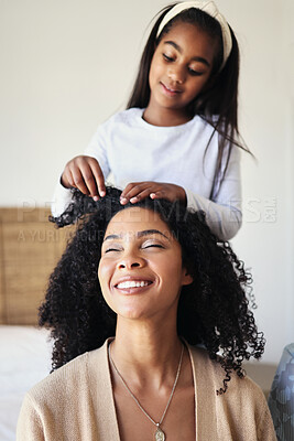 Buy stock photo Children, black family and hair with a girl styling her mother in their home for haircare or bonding. Kids, love or style with a female child and woman bonding together over a hairstyle treatment