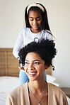 Daughter or child brushing mother hair and bonding in a home bedroom smile, adorable and happy together. Single mom, kid and mum relax spending quality time grooming in a house in happiness