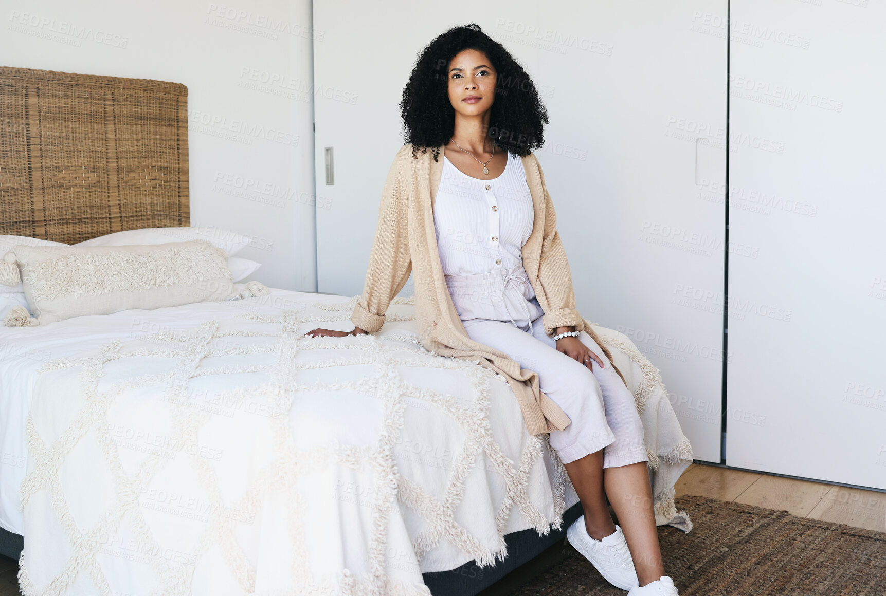 Buy stock photo Black woman relax, bedroom and home interior of a young female sitting on a bed feeling relax. House, morning and person calm on a blanket and duvet on a mattress getting ready for a nap and day rest