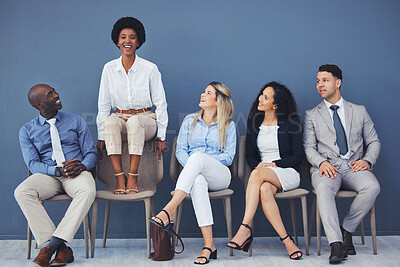 Buy stock photo Black woman, chair and smile with business people for interview with comic laugh, lobby or wall background. Group, we are hiring and waiting room with diversity, happy or opportunity at corporate job