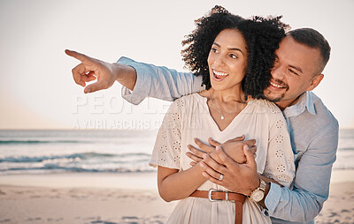 Buy stock photo Love, couple and pointing at beach on vacation, laughing and having fun together. Sunset, interracial romance and happy man and woman point for sightseeing, discovery and enjoying holiday at seashore