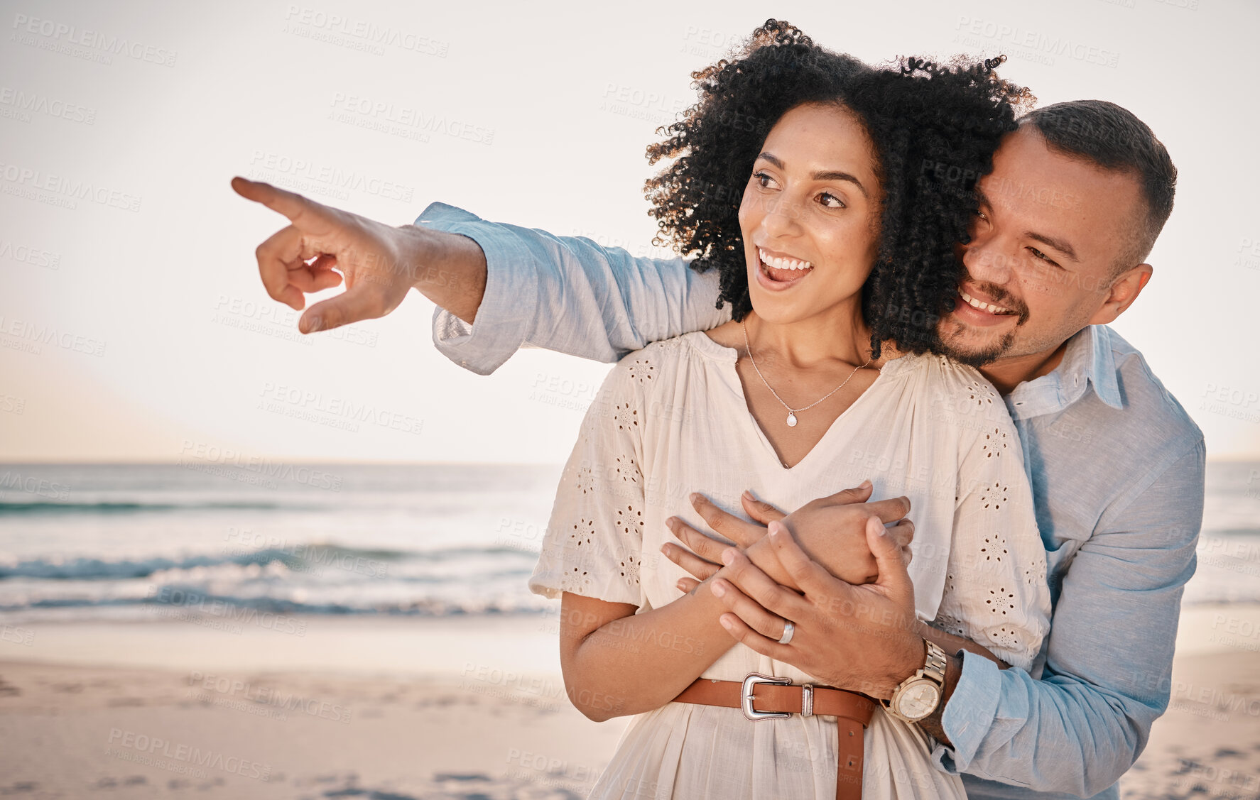 Buy stock photo Love, couple and pointing at beach on vacation, laughing and having fun together. Sunset, interracial romance and happy man and woman point for sightseeing, discovery and enjoying holiday at seashore