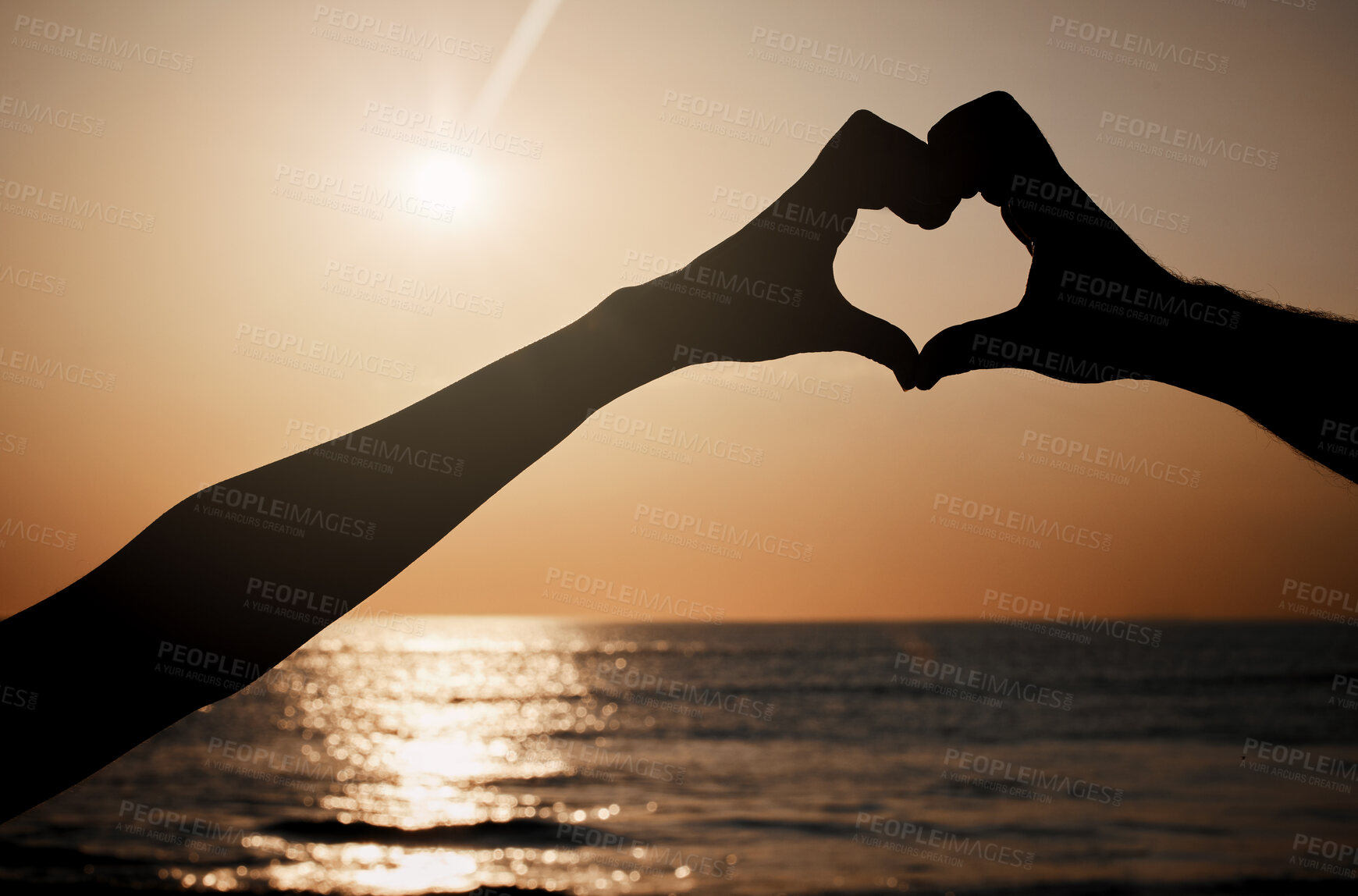 Buy stock photo Beach silhouette, sunset and heart hands sign for travel freedom, outdoor peace or nature beauty. Wellness, sky lens flare and emoji gesture for ocean love, sun light or sea water on summer holiday