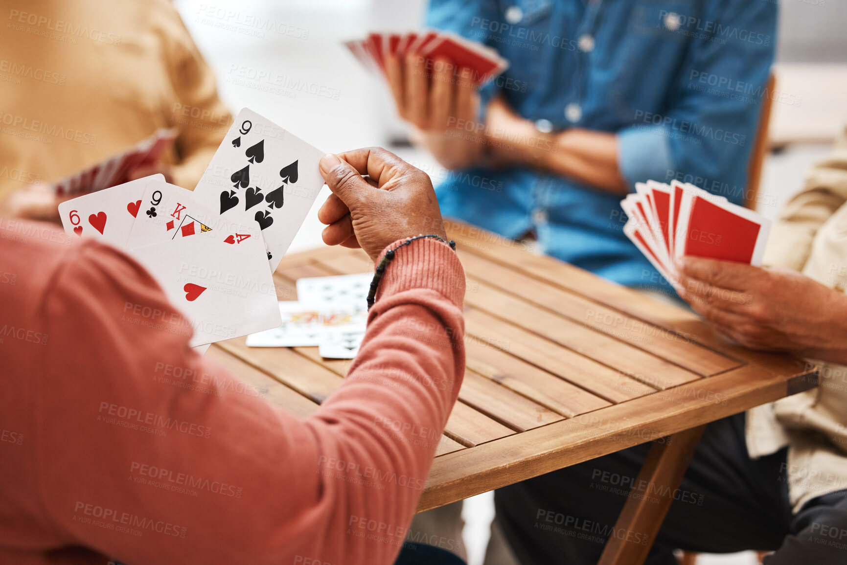 Buy stock photo Senior friends, hands or playing card games on wooden table in fun activity, social bonding or gathering. Group of elderly men having fun with cards for poker game enjoying play time together at home