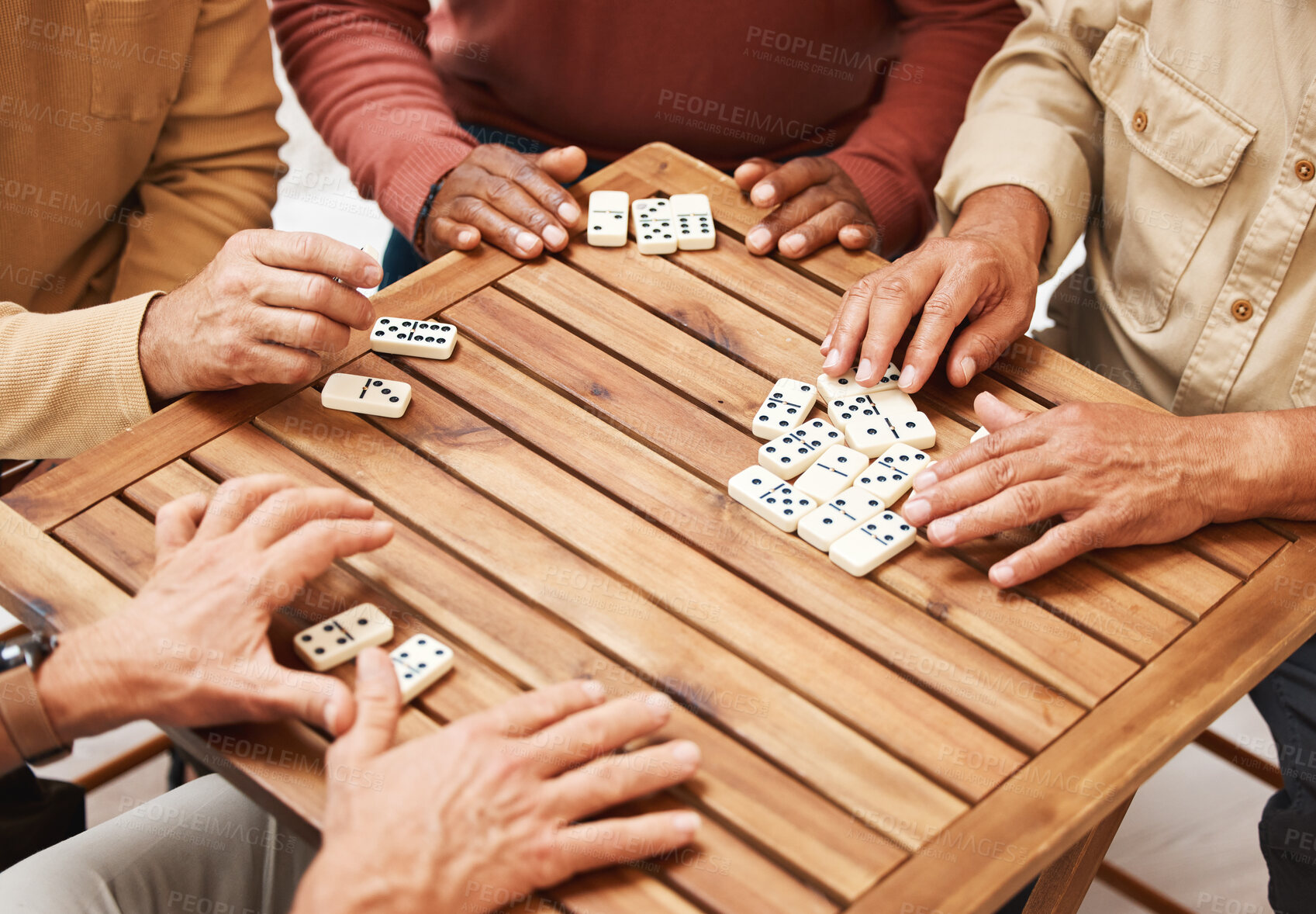 Buy stock photo Hands, dominoes and friends in board games on wooden table for fun activity, social bonding or gathering. Hand of domino players with rectangle number blocks playing in group for entertainment