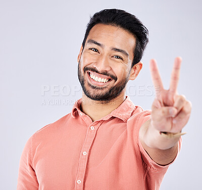 Buy stock photo Portrait, smile and peace sign of Asian man in studio isolated on a gray background. Face, v hand emoji and happy, smiling and excited, young and confident male model with gesture or peaceful symbol.