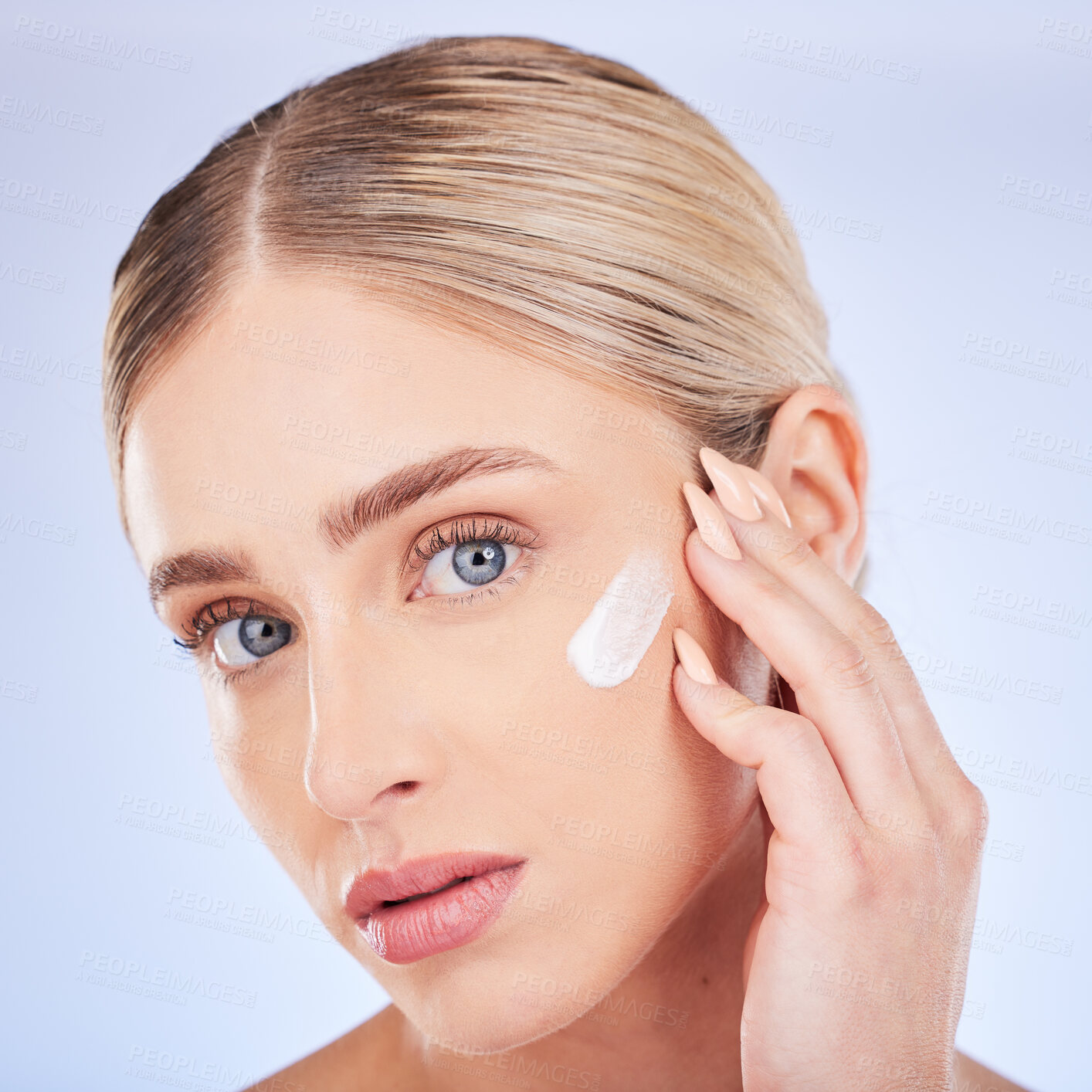 Buy stock photo Skincare, face portrait and woman with cream in studio isolated on a blue background. Dermatology closeup, beauty cosmetics and young female model apply hydration lotion, creme or moisturizer product