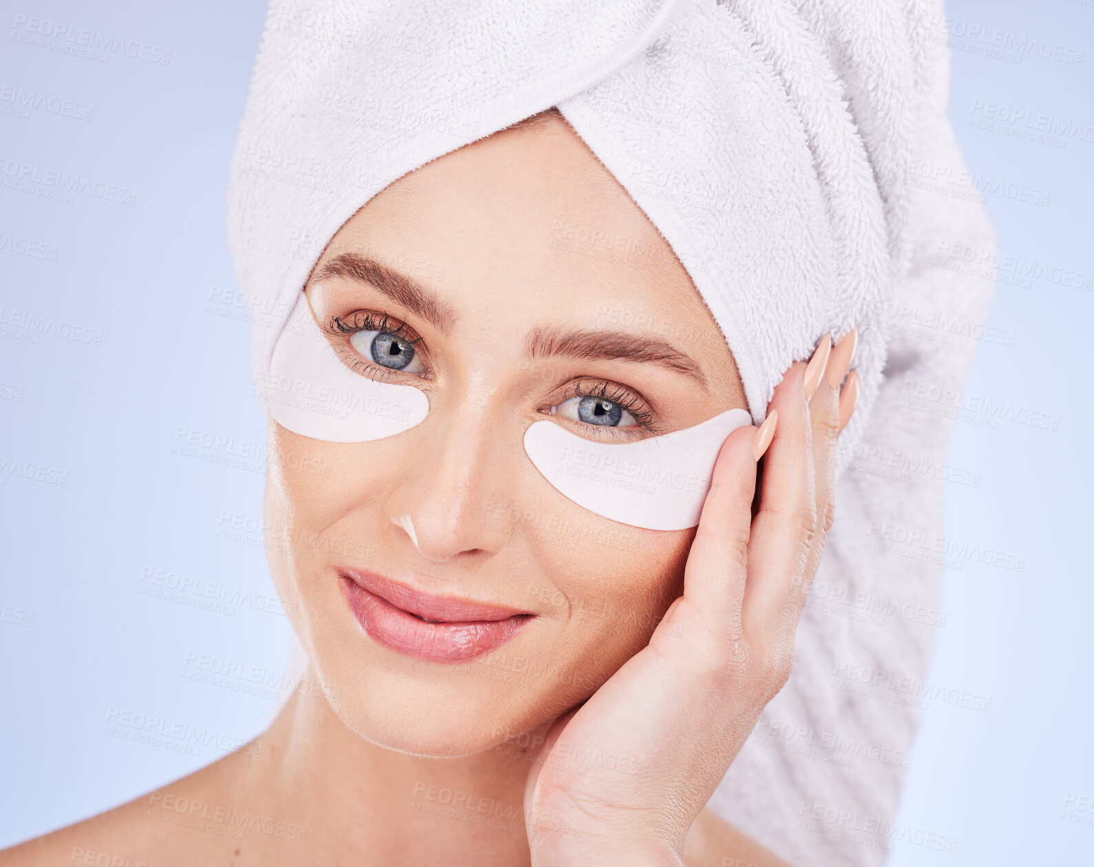 Buy stock photo Skincare, face and woman with eye patches in studio isolated on a blue background. Dermatology portrait, beauty cosmetics and happy female model with towel and collagen facial mask for healthy skin.