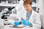 Scientist, woman and writing report with results, focus or analytics in pharma laboratory. Science expert, checklist and documents with microscope, medical innovation or study at pharmaceutical trial