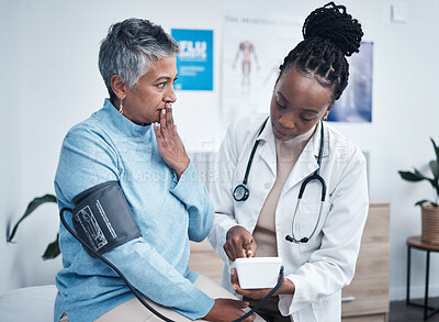 Black woman, doctor and elderly patient with blood pressure reading for wellness, advice and conversation. Medic, senior client and surprise face for health, cardiology and results in clinic office