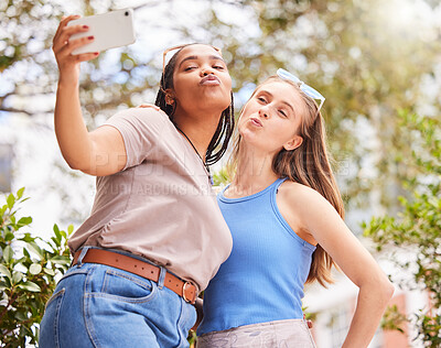 Buy stock photo Selfie, kiss and women friends bonding, chilling or hanging out outdoor in the park. Love, friendship and happy interracial females taking cute picture with a pout together in nature in green garden.