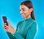 Woman, smile and typing on phone in studio for communication, social media or mobile app. Gen z model person with beauty and smartphone in hands on blue background for network connection or internet