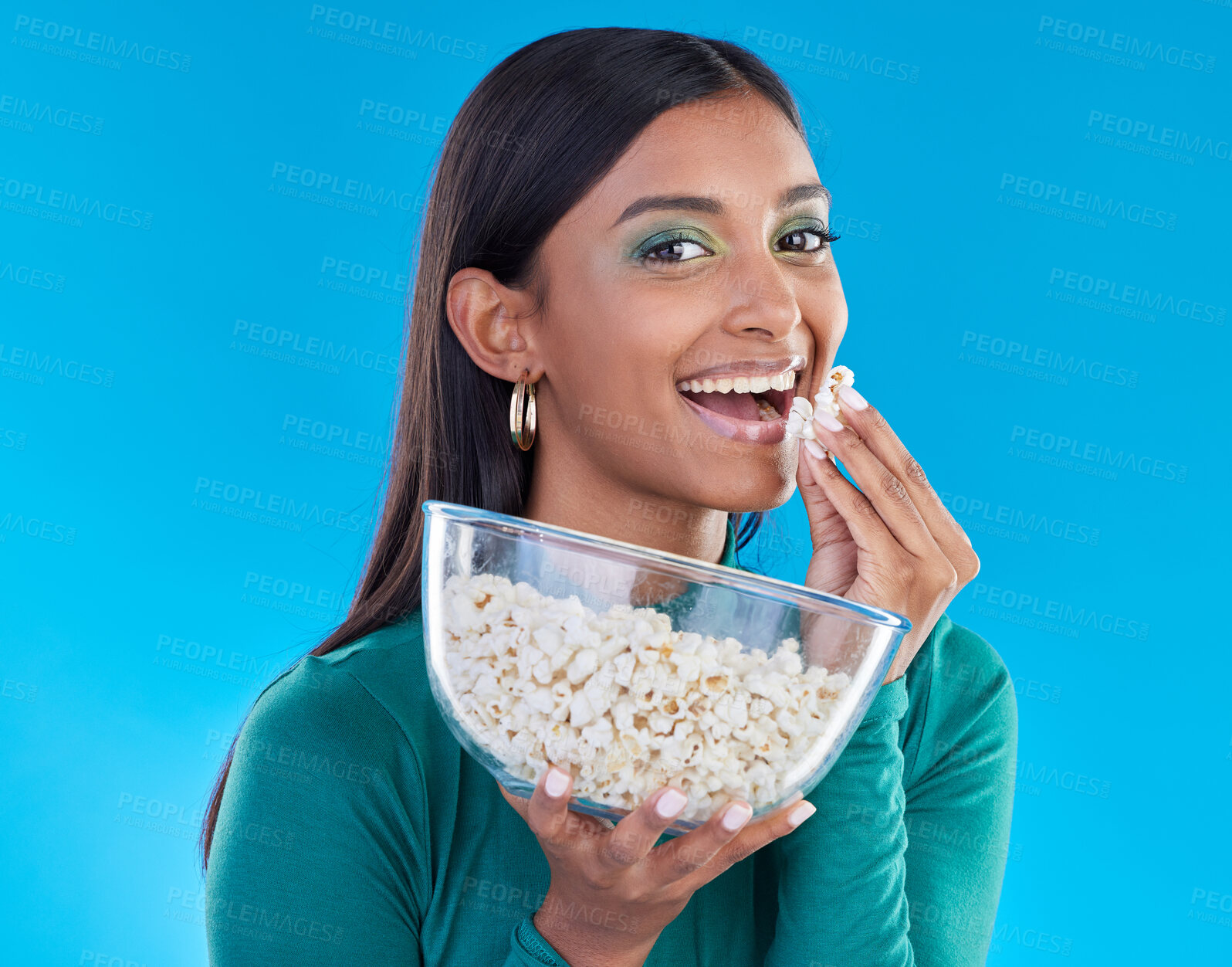 Buy stock photo Black woman, studio portrait and eating popcorn, smile or makeup for beauty, aesthetic and blue background. Gen z model, happiness and healthy corn snack for movies with cosmetics, fashion or excited