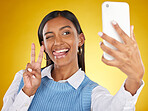 Selfie, face and peace with a woman in studio on a yellow background to post a profile picture update. Phone, social media and hand gesture with an attractive young female posing for a photograph
