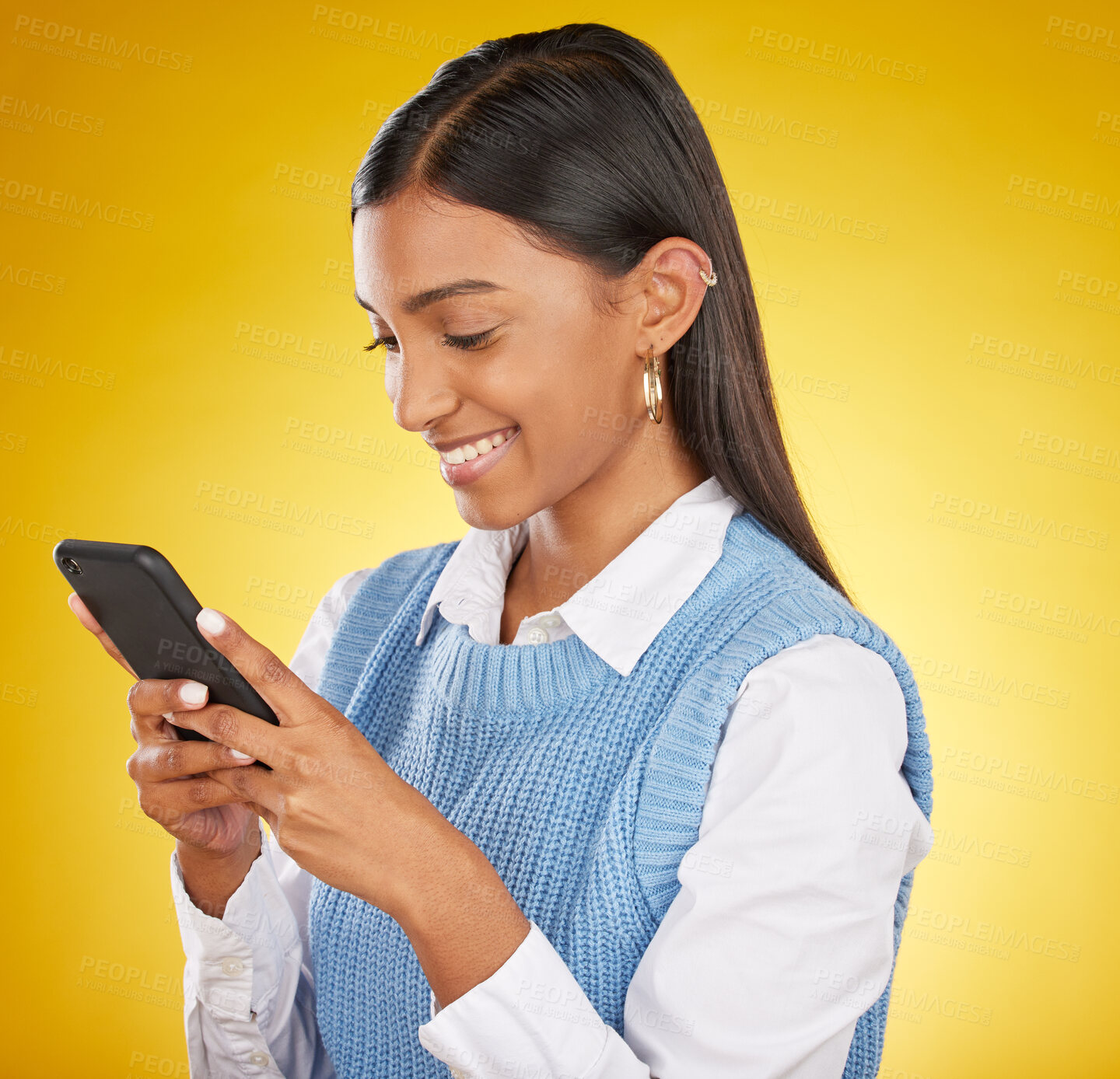 Buy stock photo Gen z woman, smile and typing on phone for communication, social media or mobile app in studio. Happy model person with smartphone in hands on a yellow background for network connection or internet
