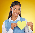 Portrait, heart cutout and smile of black woman in studio isolated on a yellow background. Face, love emoji and female with symbol, sign or gesture for romance, affection and care on valentines day.