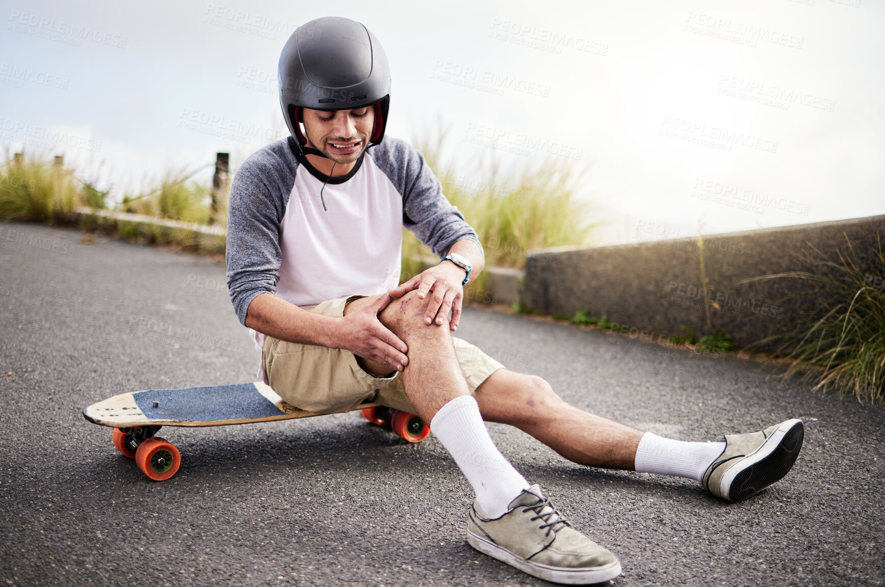 Buy stock photo Injury, man and knee pain after skateboarding fall, sports practice and learning to skate. Active, bad and skateboarder with a sprain, broken bone or holding a painful leg in the street while skating