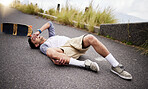 Accident, fall and knee injury with a skater man on the ground, lying down in pain after falling down. Sports, training and anatomy with a young male suffering a skateboard emergency outdoor