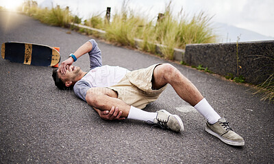 Buy stock photo Accident, fall and knee injury with a skater man on the ground, lying down in pain after falling down. Sports, training and anatomy with a young male suffering a skateboard emergency outdoor