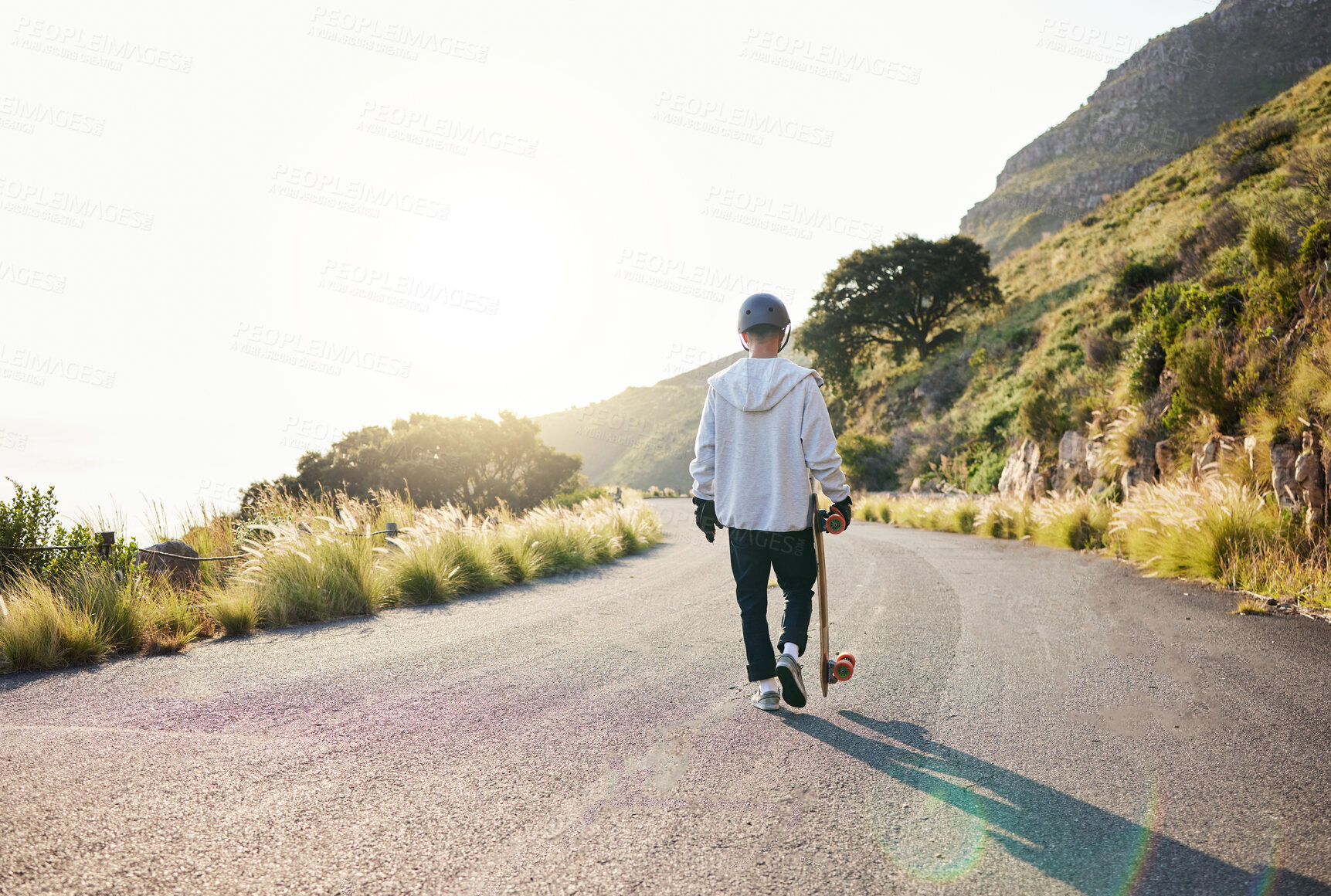 Buy stock photo Skateboard, road walking and athlete doing training, exercise and fitness on a hill. Sun, man back and summer sport of a young person ready for balance and freedom from extreme sports with mockup