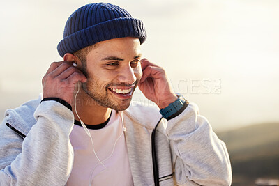 Buy stock photo Man with earphones, listening to music and smile outdoor with runner, fitness and motivation with radio streaming. Podcast, technology and exercise at sunset, happy male and running, audio and sport