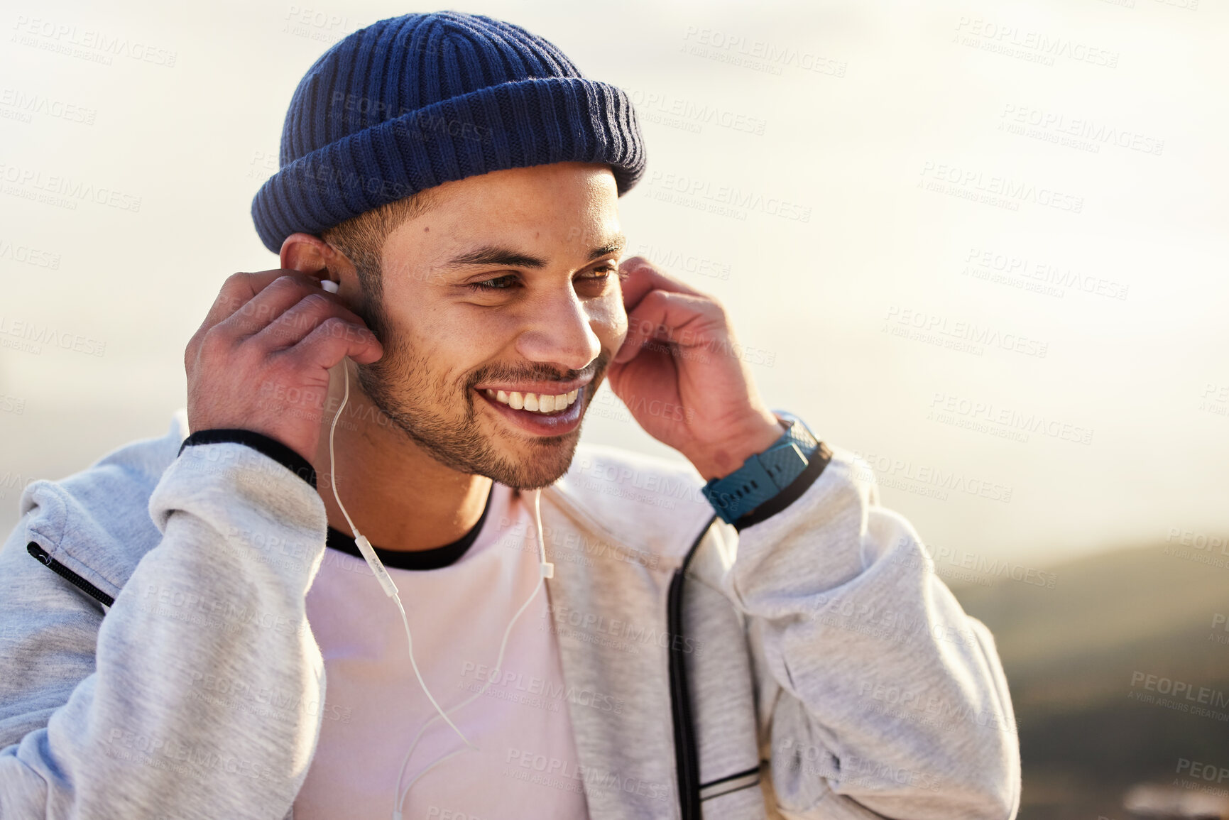 Buy stock photo Man with earphones, listening to music and smile outdoor with runner, fitness and motivation with radio streaming. Podcast, technology and exercise at sunset, happy male and running, audio and sport