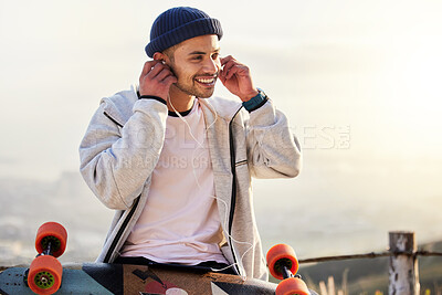 Buy stock photo Skateboarder, earphones and man listening to music, audio or podcast online and relax after skating outdoors. Skater, skateboard and person streaming to mobile radio and texting on social media